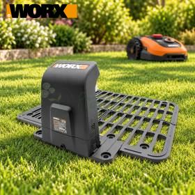 WORX Ladebasis Größe M für Mähroboter auf Rasen, mit Mähroboter im Hintergrund